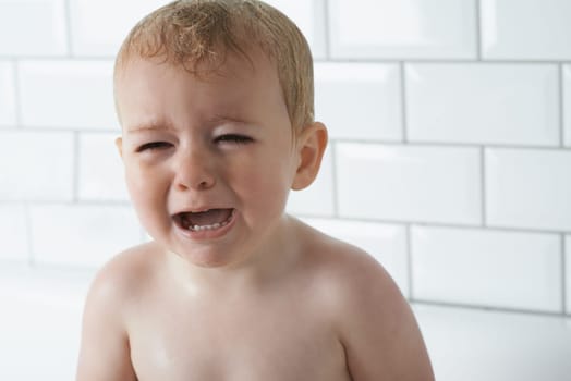 Sad, crying and baby boy at home, unhappy and distress and naughty childhood personality. Problem, emotional and frustrated young kid, bathroom and toddler with development, wet and vulnerable.