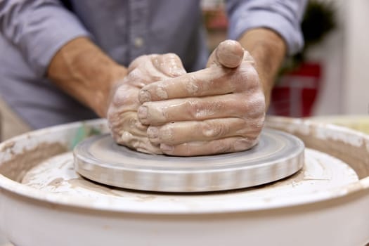 male hands making ceramic cup on pottery wheel, Close-up