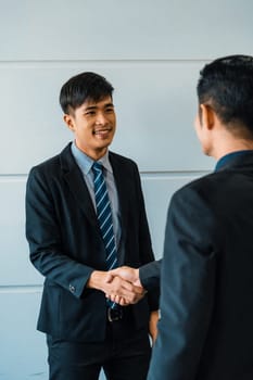Business people agreement concept. Asian Businessman do handshake with another businessman in the office meeting room. uds