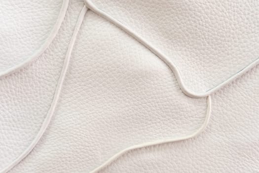 White leather texture with patterned stitching, used as a luxurious classic background. Texture and backgrounds