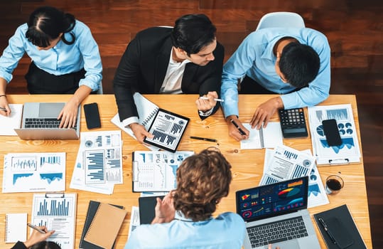 Panorama top view diverse group of business analyst team analyzing financial data report paper on meeting table. Chart and graph dashboard by business intelligence analysis. Meticulous