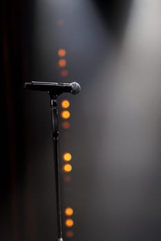 microphone on the stand on the stage backlight dark background. High quality photo