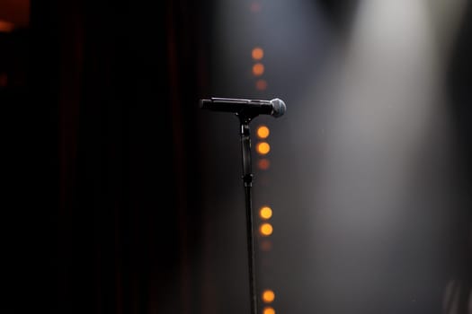 microphone on the stand on the stage backlight dark background. High quality photo