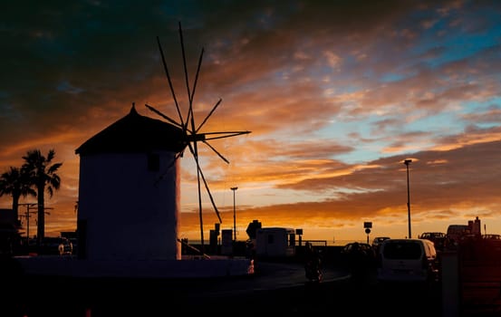 Romantic view of old traditional Greek windmill by the sea at dusk