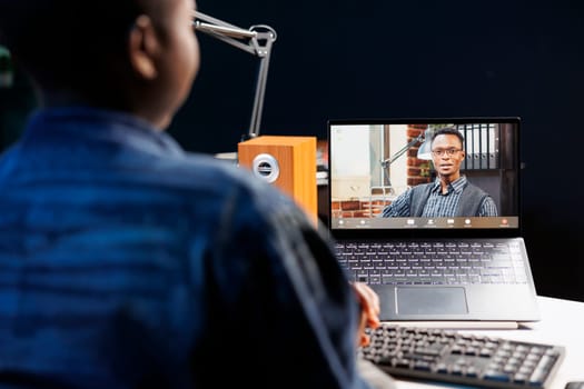 African American woman, having discussion during an online meeting on digital laptop. Female freelancer and black man use technology for virtual communication, working remotely and collaboratively.