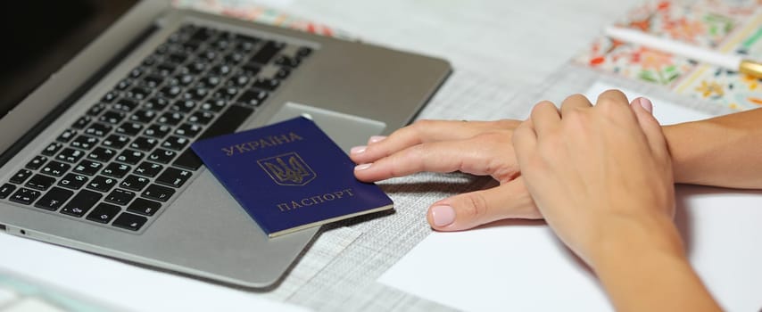 Ukrainian passport in hand near the computer. High quality photo