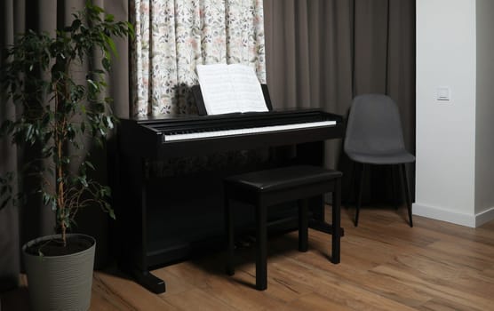 black piano and sheet music, at home. High quality photo