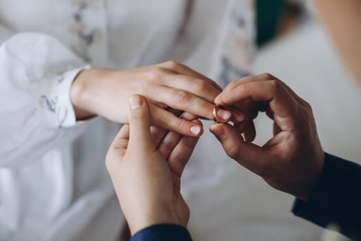 puts a wedding ring on his finger. High quality photo