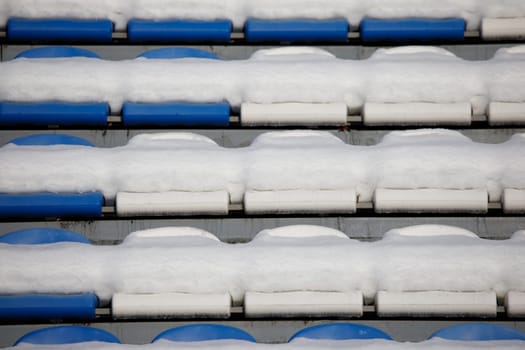 the seats of the stadium stands are covered with snow. High quality photo