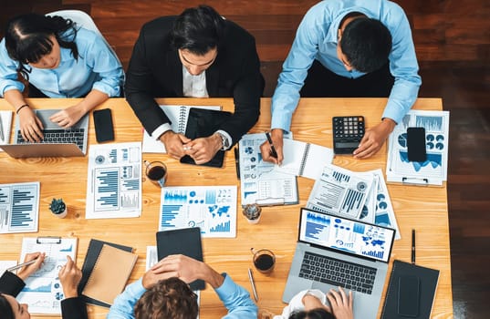 Panorama top view diverse group of business analyst team analyzing financial data report paper on meeting table. Chart and graph dashboard by business intelligence analysis. Meticulous