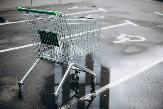 a supermarket basket is on the asvalt and a puddle of water, a wheelchair. High quality photo