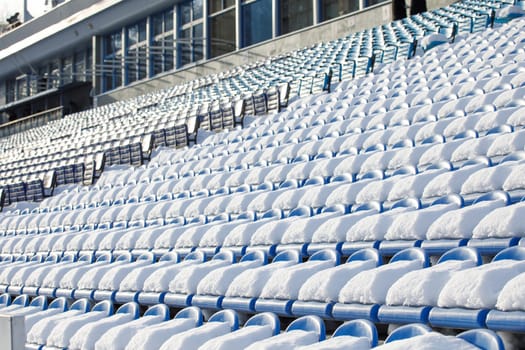 the seats of the stadium stands are covered with snow. High quality photo