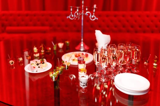 buffet table with toasts and snacks and desserts in red tones. High quality photo