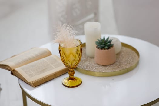 a table with a book and a vase. High quality photo