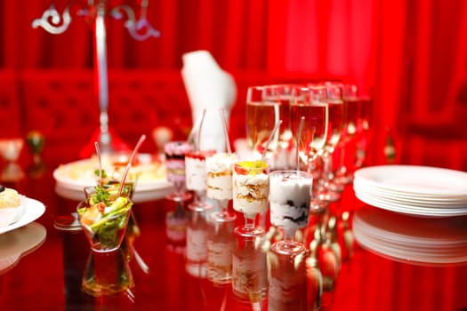 buffet table with toasts and snacks and desserts in red tones. High quality photo