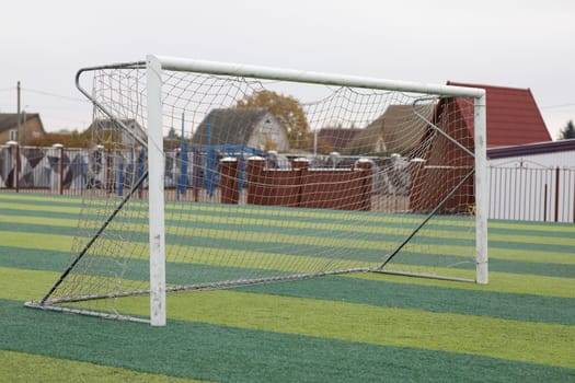 a small green soccer field and a white gate. High quality photo