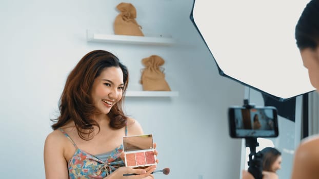 Two influencer partner shoot live streaming vlog video review makeup social media or blog. Happy young girl with vivancy cosmetics studio lighting for marketing recording session broadcasting online.