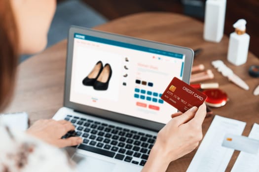 Woman shopping online on internet marketplace browsing for sale items for modern lifestyle and use credit card for online payment from wallet protected by utmost cyber security software