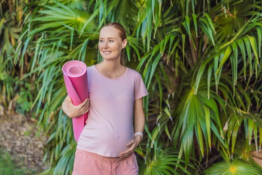 Energetic pregnant woman takes her workout outdoors, using an exercise mat for a refreshing and health-conscious outdoor exercise session.