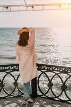 Woman travel sea. Young Happy woman in a long red dress posing on a beach near the sea on background of volcanic rocks, like in Iceland, sharing travel adventure journey