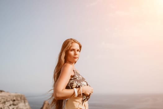 Woman travel sea. Happy tourist taking picture outdoors for memories. Woman traveler looks at the edge of the cliff on the sea bay of mountains, sharing travel adventure journey.