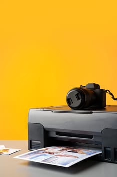 Printer printing colorful photos of people close up, yellow background, studio shot