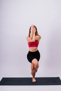 Beautiful woman doing Lotus of Padmasana or Kamalasana pose on a yoga class. Studio shot.