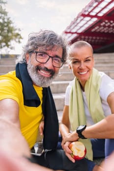 selfie photo of a smiling senior sports man with his personal trainer while they rest after training, concept of technology and healthy lifestyle