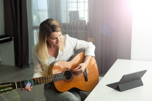 woman blogger live steam playing guitar on social media. High quality photo