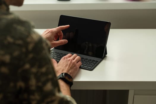Caucasian soldier in army uniform in front of computer feeling happy and excited. American soldier receiving good news. High quality photo