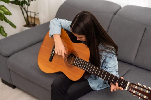 Portrait of smiling teen student practicing guitar during music lessons. High quality photo