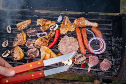 Assorted delicious grilled meat with vegetables over the coals on a barbecue. High quality photo