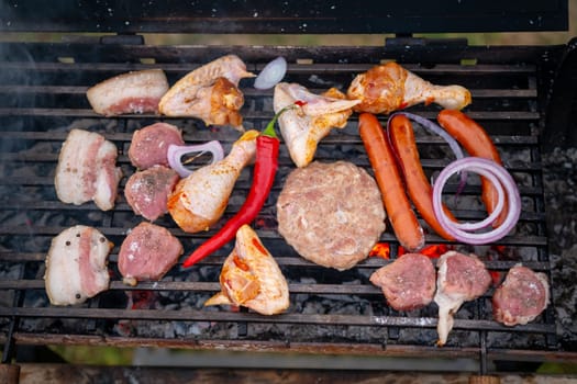 Assorted delicious grilled meat with vegetables over the coals on barbecue. High quality photo