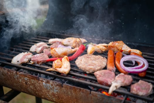 Assorted delicious grilled meat with vegetables over the coals on barbecue. High quality photo