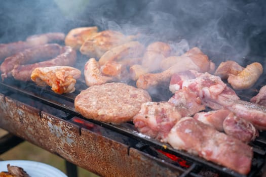 Assorted delicious grilled meat with vegetables over the coals on a barbecue. High quality photo