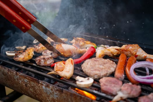 Assorted delicious grilled meat with vegetables over the coals on a barbecue. High quality photo