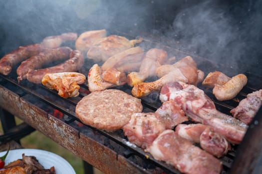 Assorted delicious grilled meat with vegetables over the coals on a barbecue. High quality photo