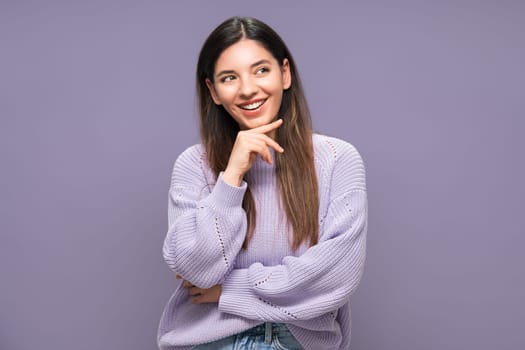 Portrait of joyful beautiful and vibrant woman in love planning in mind. Purple clothes and background.