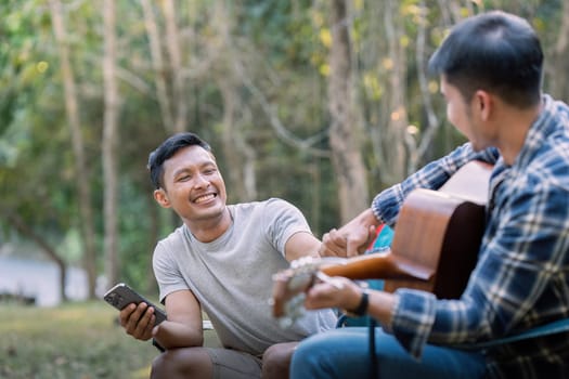 Happy Asian male gay couple on camping together in a forest. romantic vocation trip. lgbt concept.