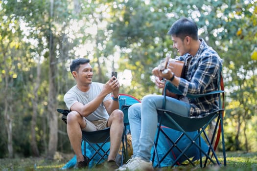 Happy Asian male gay couple on camping together in a forest. romantic vocation trip. lgbt concept.