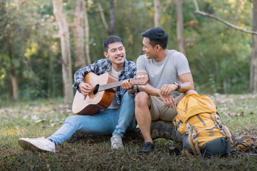 Happy Asian male gay couple on camping together in a forest. romantic vocation trip. lgbt concept.