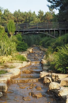 small waterfall with walking bridge at public park ,