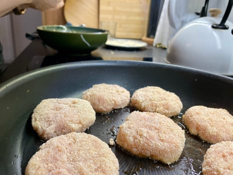 Delicious meat cutlets are being fried in a frying pan in the kitchen. High quality photo