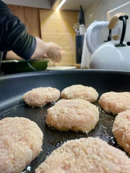 Delicious meat cutlets are being fried in a frying pan in the kitchen. High quality photo