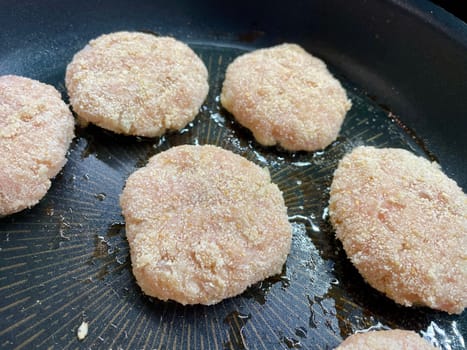 Delicious meat cutlets are being fried in a frying pan in the kitchen. High quality photo