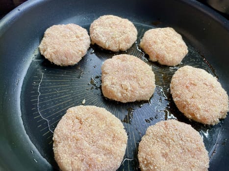 Delicious meat cutlets are being fried in a frying pan in the kitchen. High quality photo