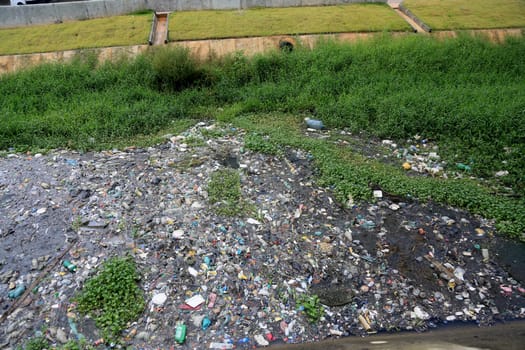 salvador, bahia, brazil - september 12, 2023: view of a river channel with lots of dirt and pollution in the city of Salvador.