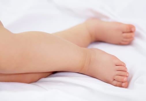 Feet, baby and legs of kid on bed for sleep, calm break and relax in nursery room at home. Closeup, foot and toes of tired young child asleep for newborn development, healthy childhood growth or rest.