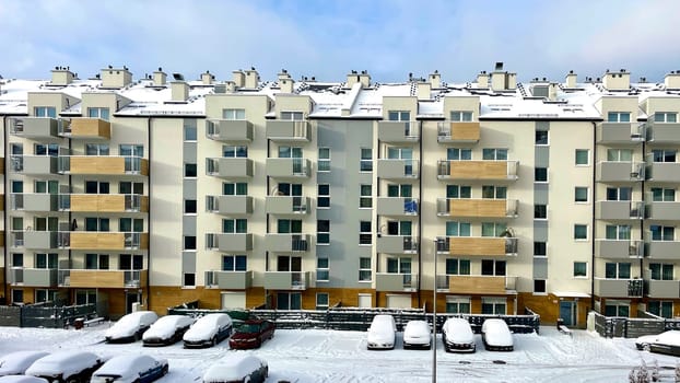 A high-rise building in the city against the background of a blue sky with white clouds. High quality photo