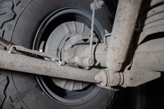 Rear suspension. View from below. SUV suspension in dust.